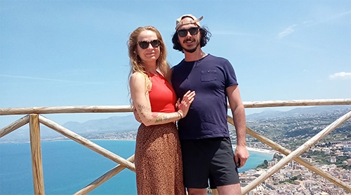 donna in spiaggia, coricata su un'amaca, con gli occhiali da sole che guarda il mare completamente rilassata